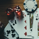 Playing cards, dice, and poker chips arranged.