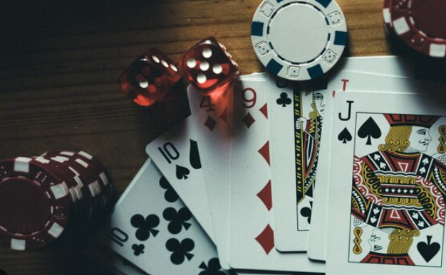 Playing cards, dice, and poker chips arranged.